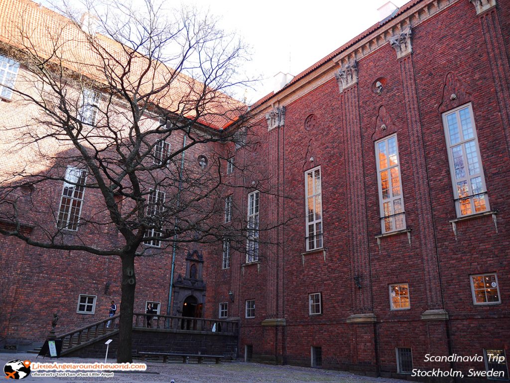 ใบไม้ช่วงผลัดใบ มองผ่านไปยังผนังอาคารอิฐแดง คล้ายภาพวาดงานศิลป์ ณ ศาลาว่าการเมืองสตอกโฮล์ม – Stockholms stadshus (Stockholm City Hall) 